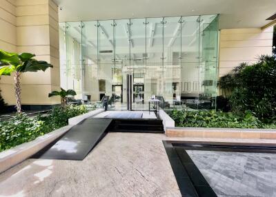 Modern entrance lobby with glass doors and lush greenery