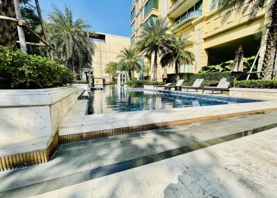 Outdoor pool area of a modern apartment complex with palm trees