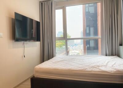Modern bedroom with large window and wall-mounted TV