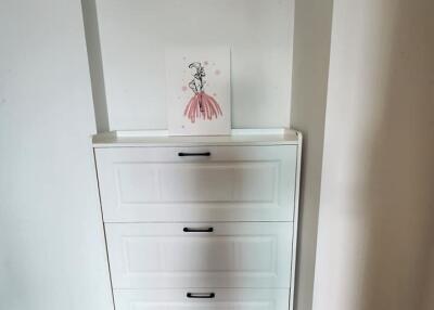 Hallway with white drawer chest and decorative wall art
