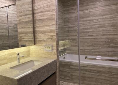 Modern bathroom with tiled walls, glass shower, and bathtub