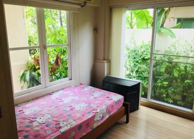 Bedroom with large window and sliding glass door, featuring a pink bedspread