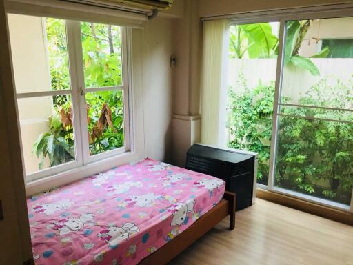 Bedroom with large window and sliding glass door, featuring a pink bedspread