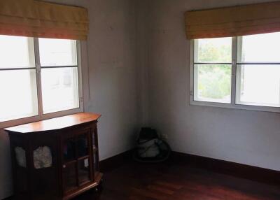 Empty bedroom with hardwood floors and windows