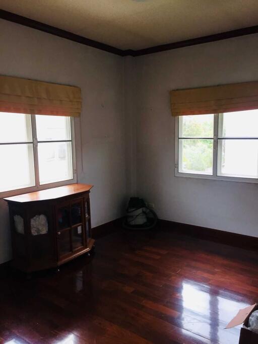 Empty bedroom with hardwood floors and windows