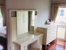 Bright bedroom with a dressing table and chest of drawers