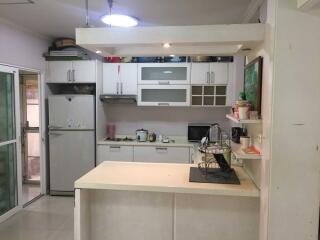 Modern kitchen with white cabinetry, counter island, and appliances