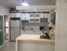 Modern kitchen with white cabinetry, counter island, and appliances