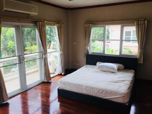 Spacious bedroom with large windows and balcony access