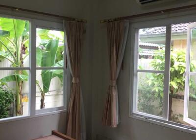 Bedroom with windows showing a garden view and air conditioning