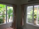 Bedroom with windows showing a garden view and air conditioning