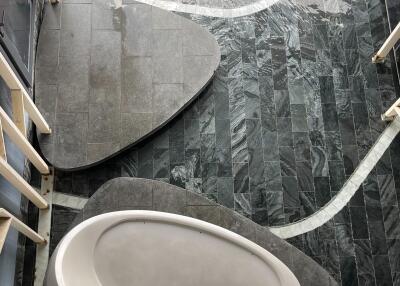 Modern bathroom with large ceramic bathtub and marble flooring