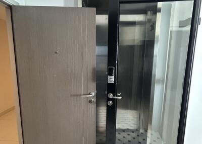 Main entry door with glass partition and adjacent elevator