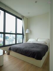 Bedroom with large windows and city view