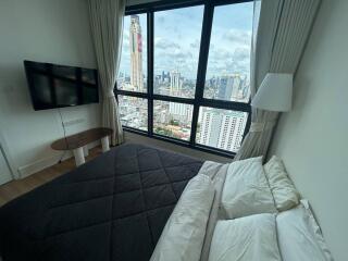 Bedroom with a large window offering a city view