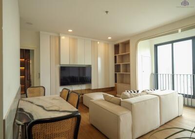 Spacious and modern living room with comfortable seating, large windows, and built-in storage.