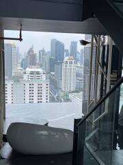 view of cityscape from high vantage point inside a building with a modern staircase