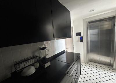 Modern kitchen with black cabinets and an adjacent elevator