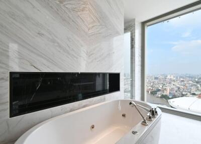 Modern bathroom with a bathtub and a large window with a city view