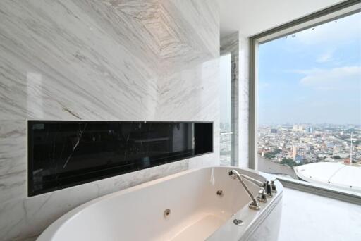 Modern bathroom with a bathtub and a large window with a city view