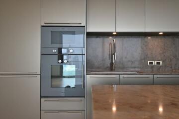 Modern kitchen with built-in appliances and marble countertop