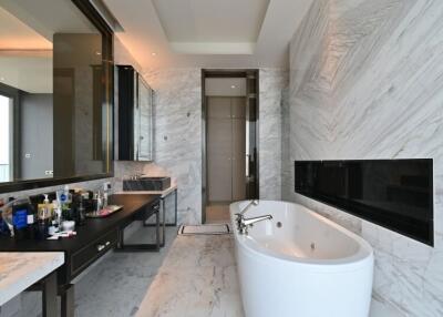Luxury modern bathroom with marble walls, a freestanding bathtub, and a large mirror