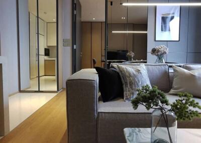 Contemporary living room with a gray sofa, decorative pillows, and a coffee table with a plant.