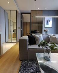 Contemporary living room with a gray sofa, decorative pillows, and a coffee table with a plant.