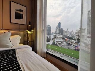 Bedroom with a large window overlooking a city skyline