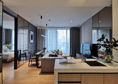 Open plan living room and kitchen area with a view of the bedroom and large windows