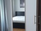 Bedroom with wooden flooring, large wardrobe with mirror, and double bed
