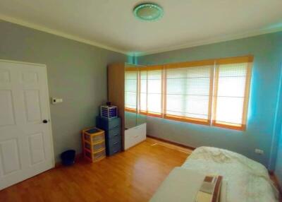 Spacious bedroom with wooden flooring and ample natural light