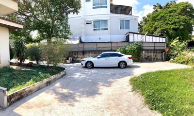 Front view of the property featuring a white car parked in the driveway