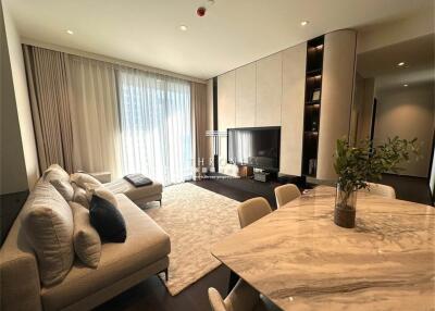 Modern living room with contemporary decor, including a sofa, TV, and dining area with a marble table