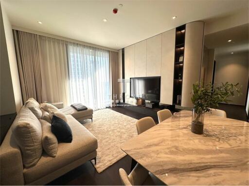 Modern living room with contemporary decor, including a sofa, TV, and dining area with a marble table