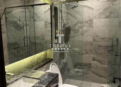 Modern bathroom with glass-enclosed shower and marble countertops