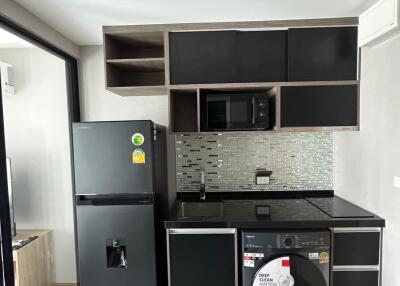 Modern compact kitchen with black appliances and mosaic backsplash