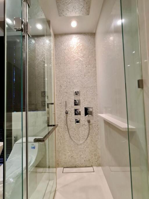 Modern bathroom with glass shower enclosure and white toilet