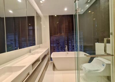 Modern bathroom with a glass shower, bathtub, and double sink vanity