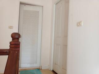 Hallway with wooden railing and closed doors