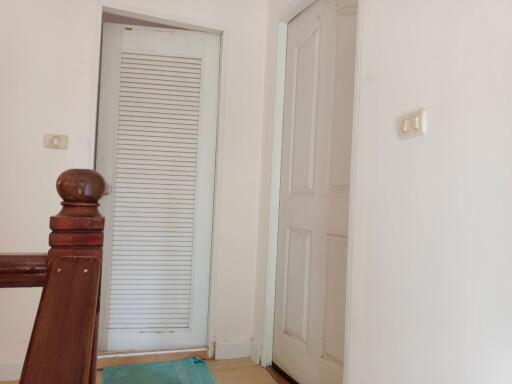 Hallway with wooden railing and closed doors