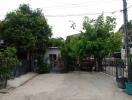 Front view of a residential property with a driveway and trees