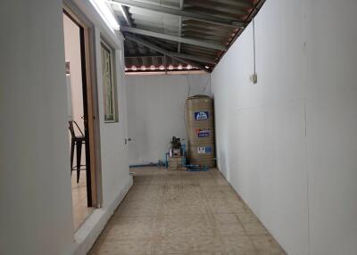 Covered utility area with water tank and tiled floor