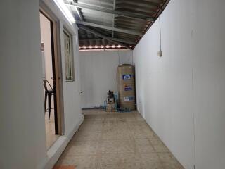 Covered utility area with water tank and tiled floor