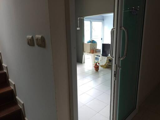 View of an entryway leading into a room with tiles and some furniture