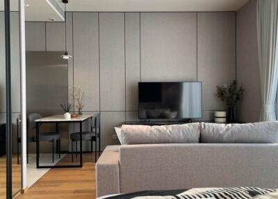 Modern living room with gray sofa, TV, and dining area