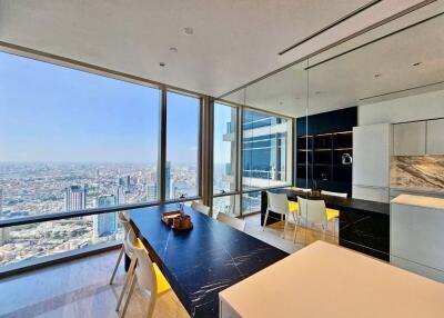 Modern dining area with a panoramic city view and a sleek kitchen