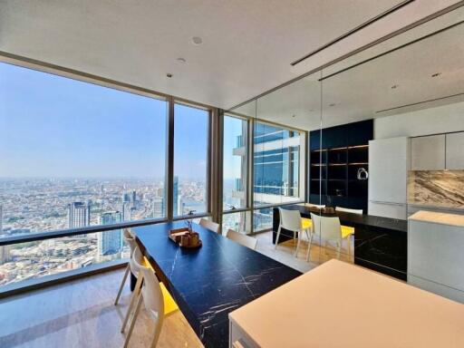 Modern dining area with a panoramic city view and a sleek kitchen