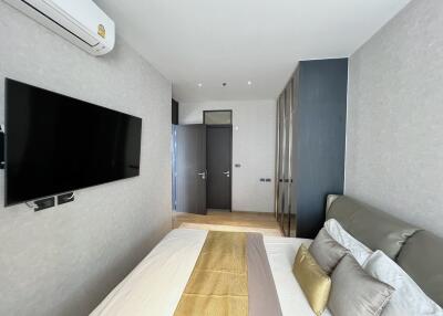 Modern bedroom with wall-mounted TV and air conditioning