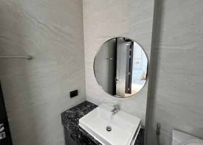 Modern bathroom with a round mirror and a marble countertop